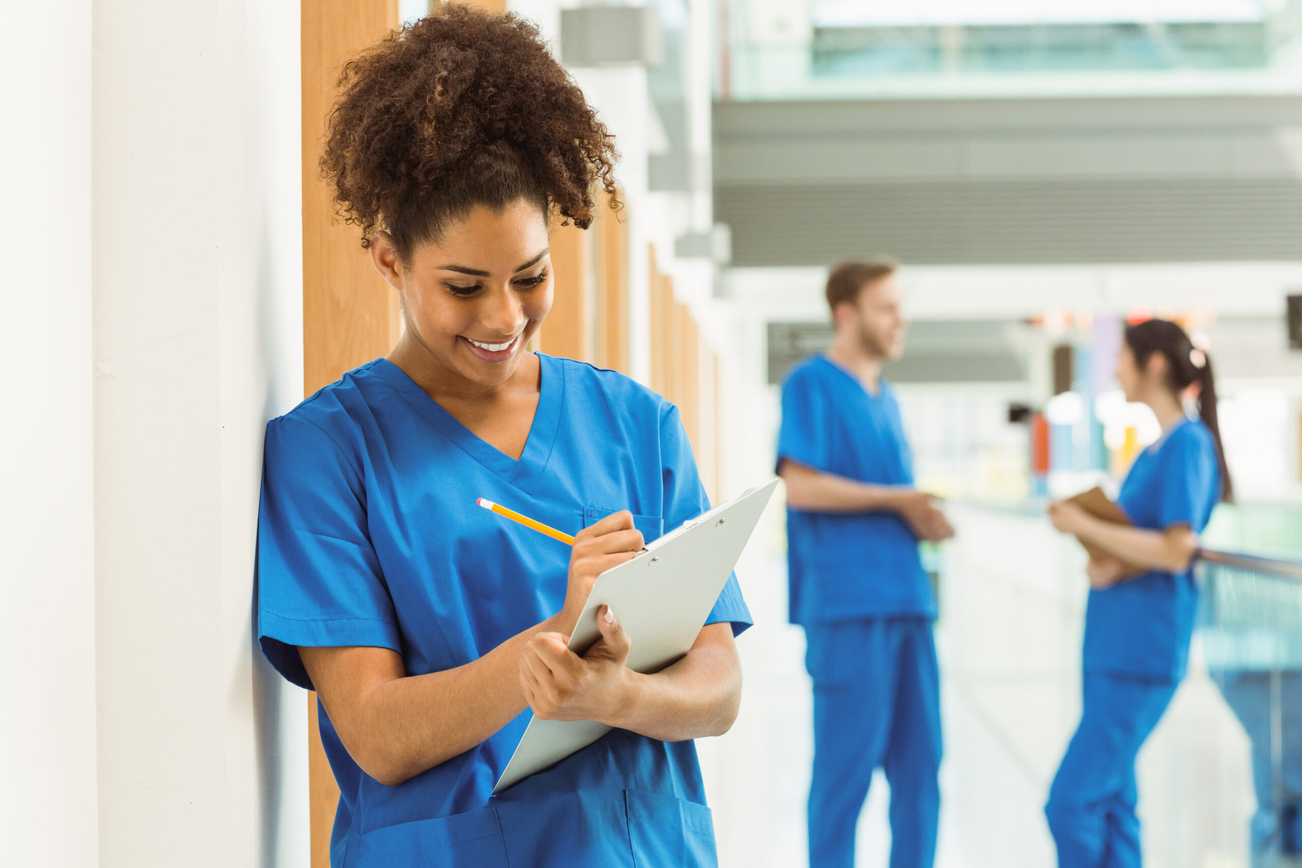 Medical student taking notes in hallway at the university
